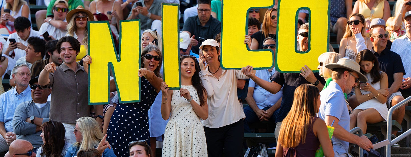 Family holding letters that spell NICO spot their graduate